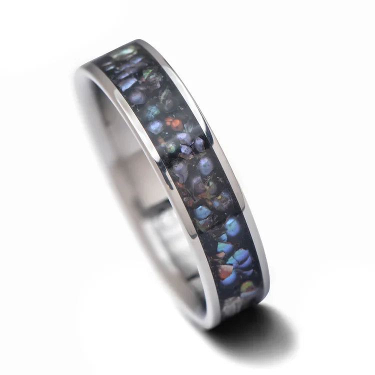 Titanium wedding band featuring a central black pearl inlay, 6mm mens ring with a polished flat profile, available with free engraving, displayed on a white background.