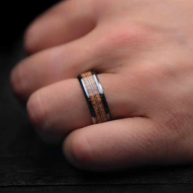 Black titanium wedding band with dual walnut and guitar string inlays, 8mm mens ring, polished bevel profile, displayed on a white sea branch, free engraving available.