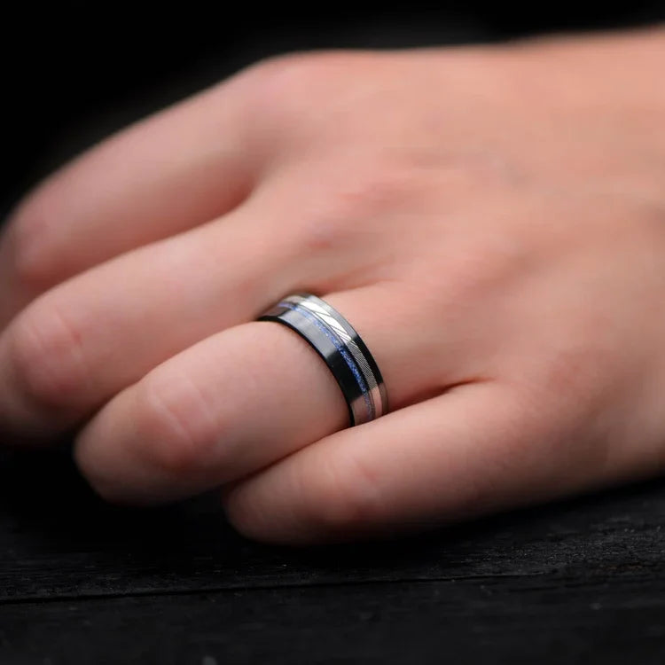 Black titanium wedding band with dense twist and lapis lazuli inlays on a hand, showcasing a unique mens ring design with free engraving, 7mm width.