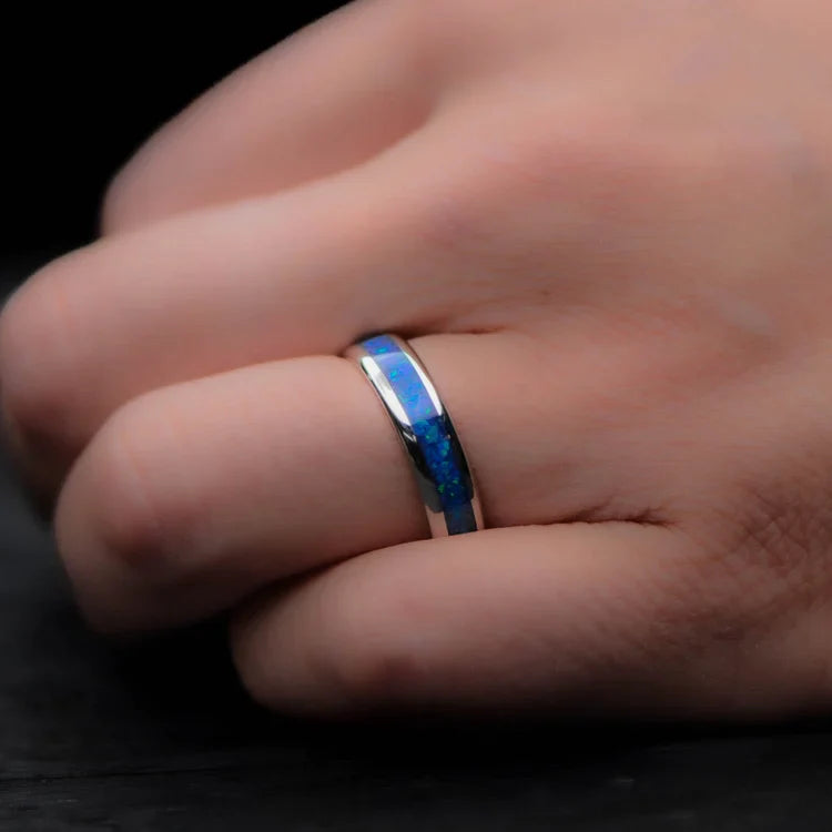 Platinum wedding band with blue opal inlay on a hand, featuring a polished domed profile, 6mm mens ring, unique design with free engraving option.