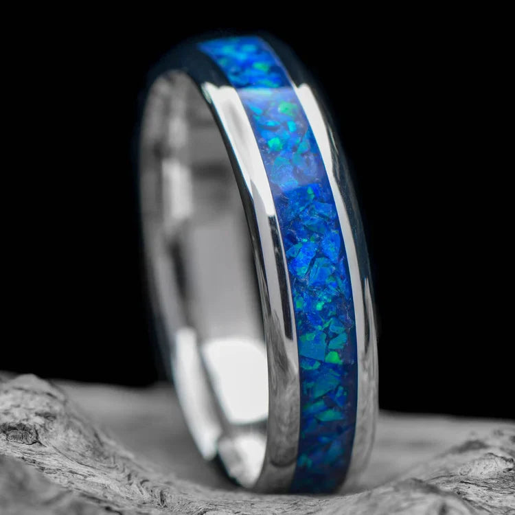 Platinum wedding band with blue opal inlay, free engraving, 6mm mens ring, polished domed profile, unique mens ring on white sea branch background.
