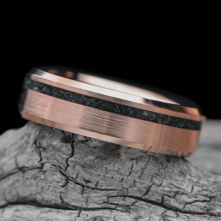 14K rose gold wedding band with moss agate inlay, 6mm mens ring featuring a brushed bevel profile, unique design, free engraving available, displayed on a white sea branch.