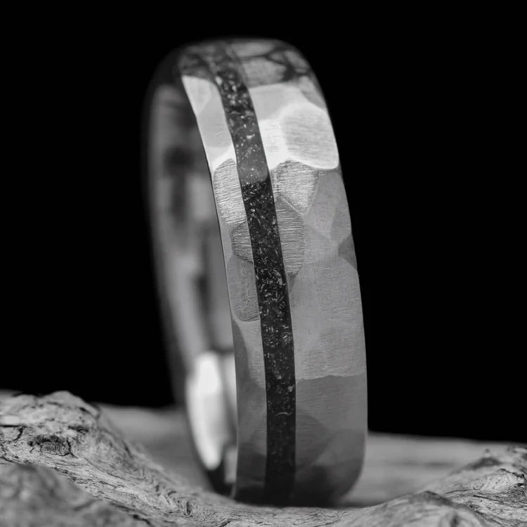 Titanium wedding band with meteorite inlay, 7mm mens ring featuring a unique faceted domed design, displayed on a white sea branch, free engraving available.