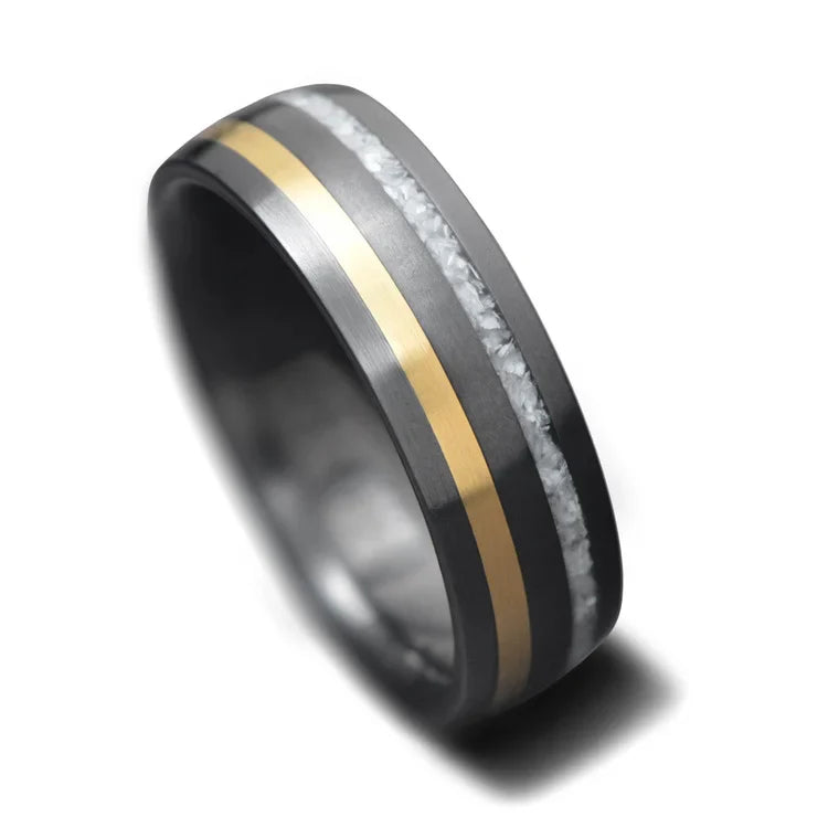 Mens 7mm black titanium wedding band with pearl and 18KY inlays, brushed domed profile, unique design, free engraving option, on white background.
