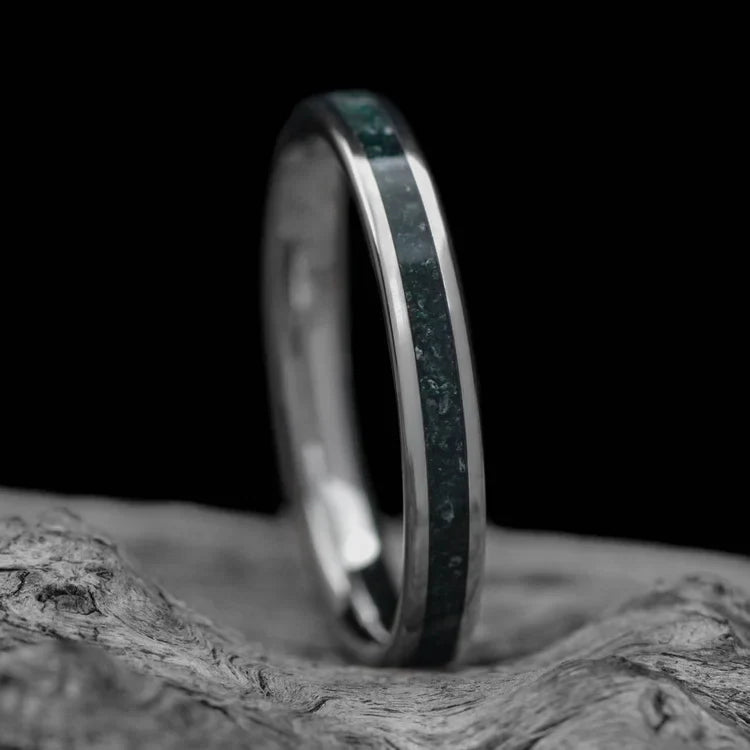 Titanium wedding band with central moss agate inlay, 3mm womens custom ring, free engraving, displayed on white sea branch.