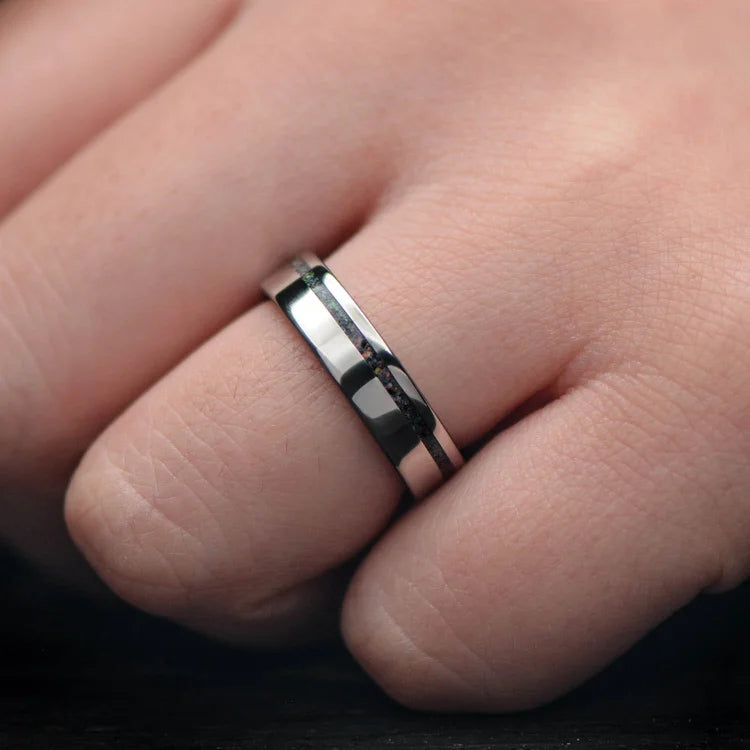 Titanium wedding band with black fire opal inlay, 5mm polished flat profile, custom simple ring with free engraving, displayed on a white sea branch.