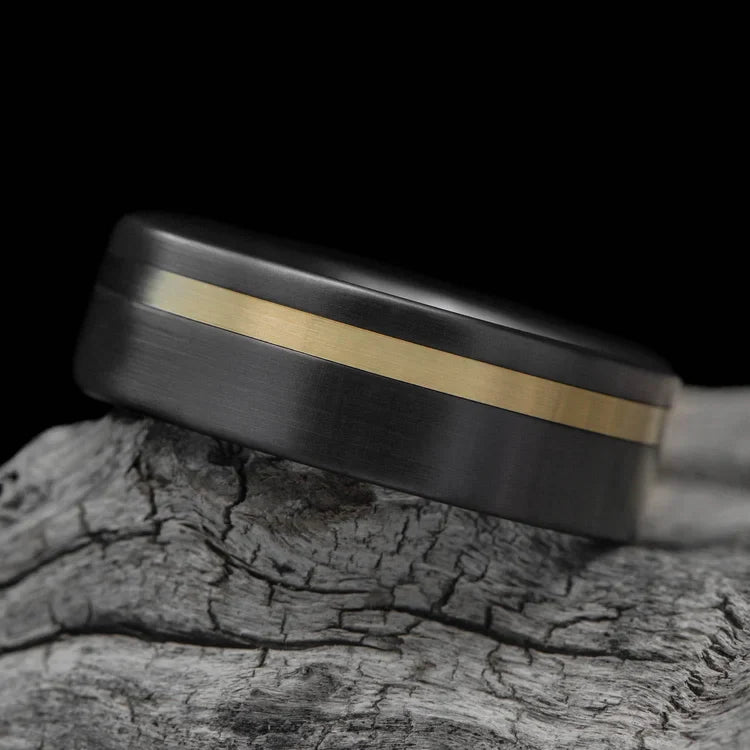 Zirconium wedding band with 14K yellow gold inlay, 8mm mens ring with brushed flat profile, custom design, free engraving, displayed on white sea branch.