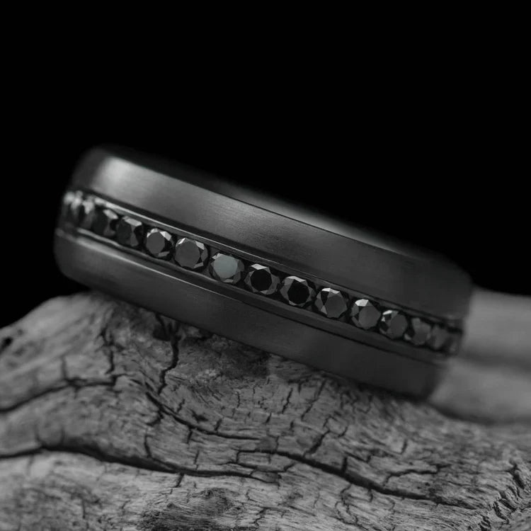 Zirconium wedding band with eternity set precious stone, mens 8mm brushed domed profile ring, free engraving, displayed on a white sea branch.
