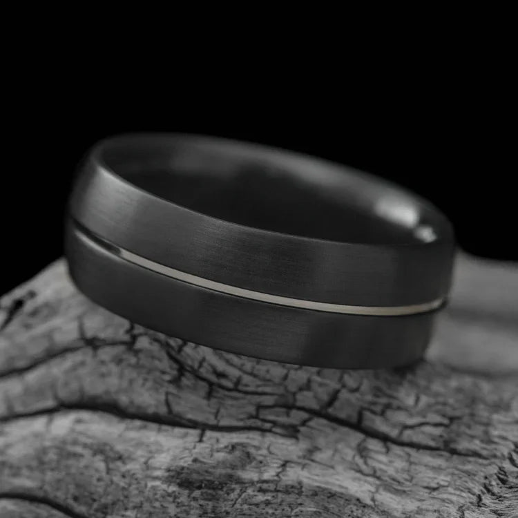 Zirconium wedding band with 14KW inlay, mens 8mm brushed domed profile ring, unique design, free engraving, displayed on white sea branch.