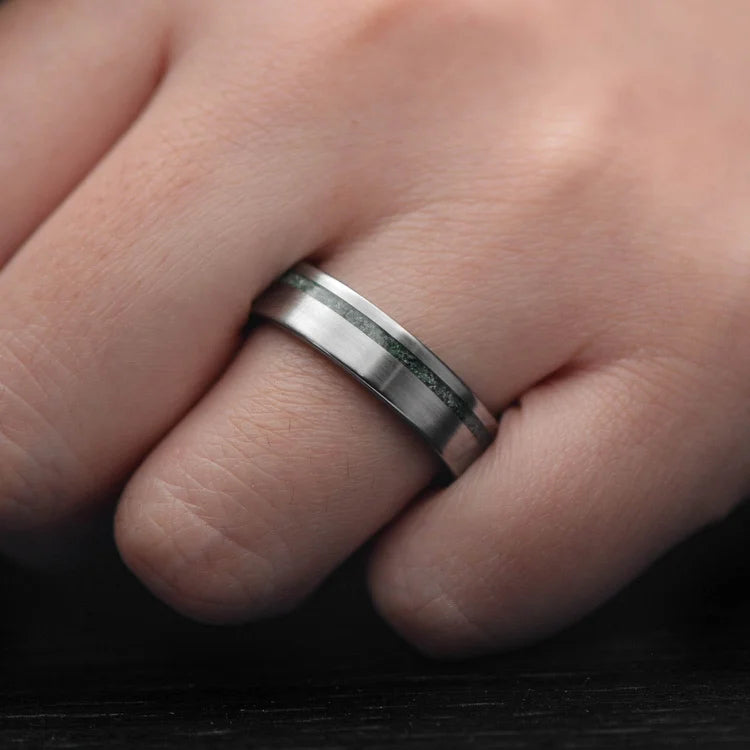 Titanium wedding band with moss agate and meteorite inlay, 6mm mens ring, unique brushed flat profile, free engraving, displayed on white sea branch.