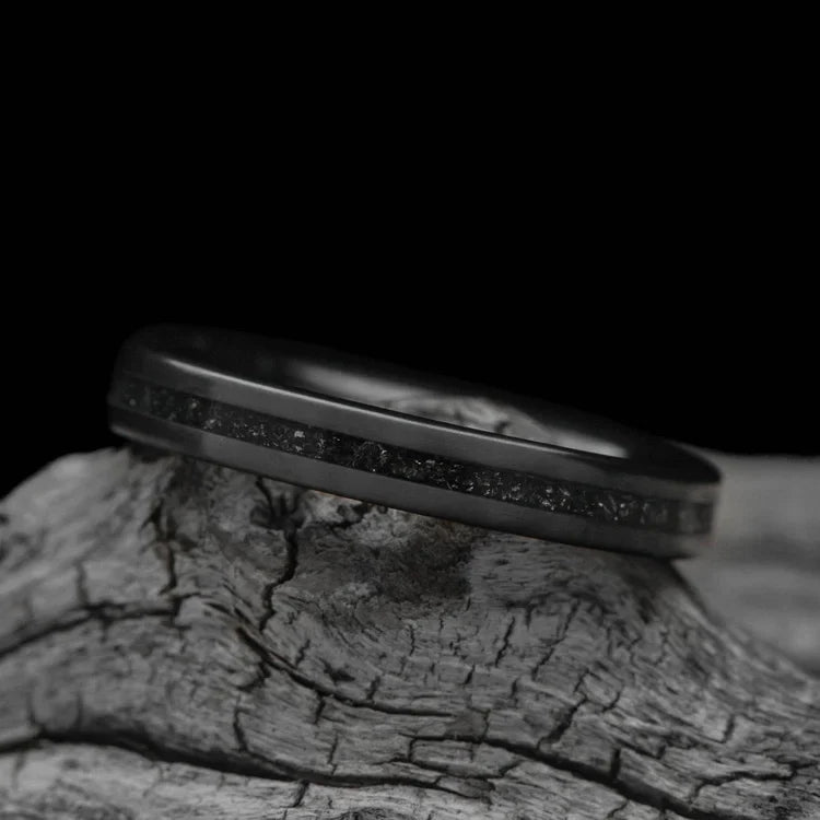  Black Titanium wedding band with central meteorite inlay, 3mm womens unique custom ring, free engraving, displayed on a white sea branch.