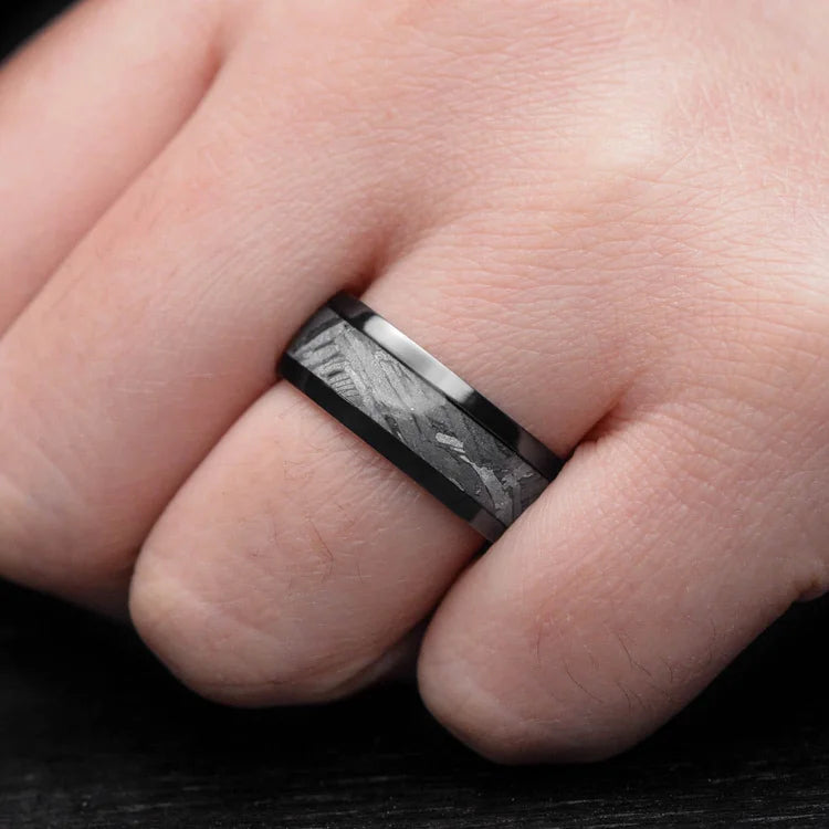 Black titanium ring with solid meteorite central inlay on a hand, showcasing an 8mm mens wedding band with free engraving, unique design for mens wedding rings.