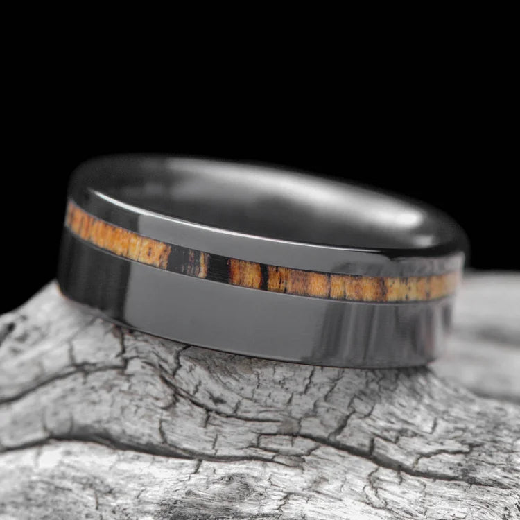 Mens black titanium wedding band with silver spalted birch inlay, 7mm polished flat profile, shown on a hand, free engraving available.