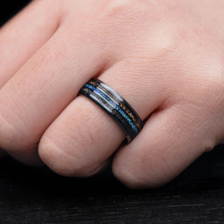 Mens wedding band on hand, featuring a black titanium ring with meteorite, crushed T-Rex bone, and blue opal central inlay, 7mm width, unique design with free engraving option.