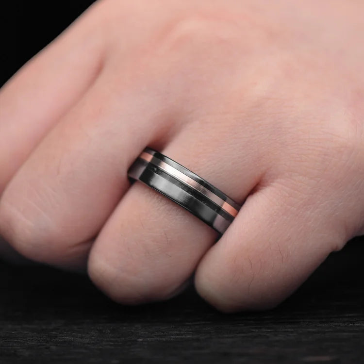 Mens Black Titanium Wedding Band with 10K Rose Gold and Black Onyx Inlays, Black Fire Opal Inner Sleeve, 7mm, shown on hand, brushed finish, free engraving available.