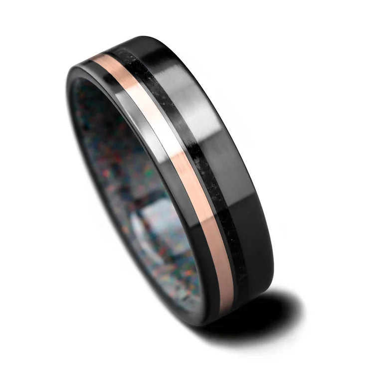 Black titanium wedding band with 10K rose gold and black onyx inlays, featuring a black fire opal inner sleeve, 7mm brushed mens ring, free engraving, on white background.