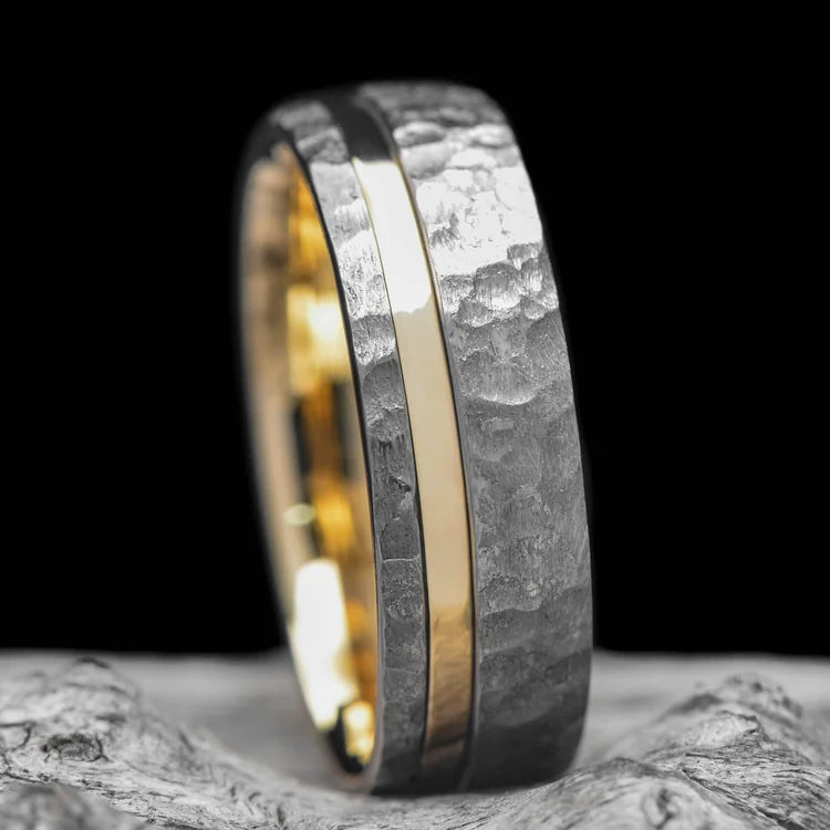 Faceted tantalum wedding band with 14K yellow gold inlay and inner sleeve, 8mm mens ring, unique design, free engraving, displayed on white sea branch.