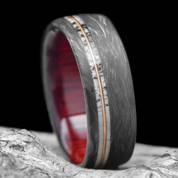 Mens 8mm wedding band on white sea branch, featuring a forged design with dual deer antler and central guitar string inlays, bloodwood sleeve, brushed finish, free engraving available.