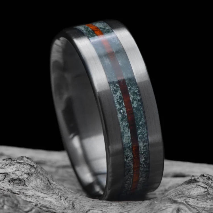 Black Titanium Wedding Band with Moss Agate and Central Koa Inlay, 8mm Mens Wedding Ring, Unique Design, Free Engraving, displayed on white sea branch.