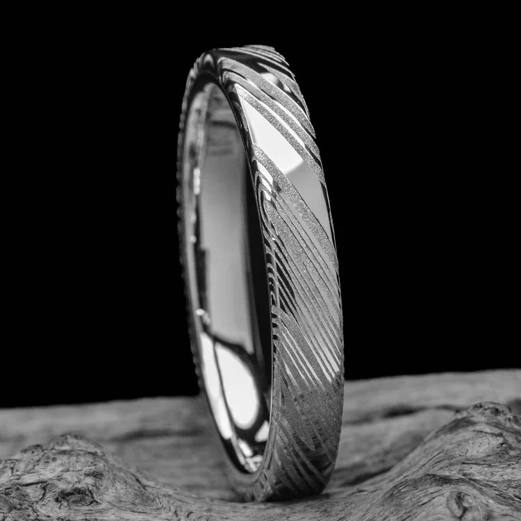 Heimskringla wedding band with 10KW inner sleeve, 4mm custom flat profile ring with polished finish, simple custom design, free engraving, displayed on a white sea branch.