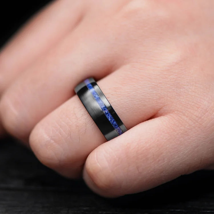 Hand wearing a Black Titanium Ring with Lapis Lazuli Inlay and Whiskey Barrel Oak Sleeve, 7mm Mens Wedding Band, unique design with free engraving option.
