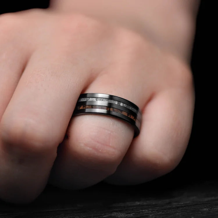 Mens black titanium wedding band with solid meteorite and T-Rex inlays, 7mm, unique design, free engraving, worn on a hand.