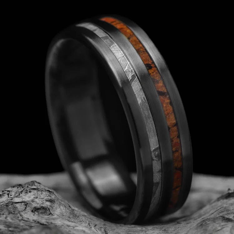 Black titanium wedding band with solid meteorite and T-Rex inlays, 7mm mens ring, unique design, free engraving, displayed on white sea branch.