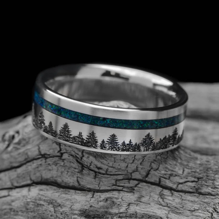 Titanium wedding band with black emerald opal inlay, 7mm mens ring, unique design, free engraving, displayed on a white sea branch.