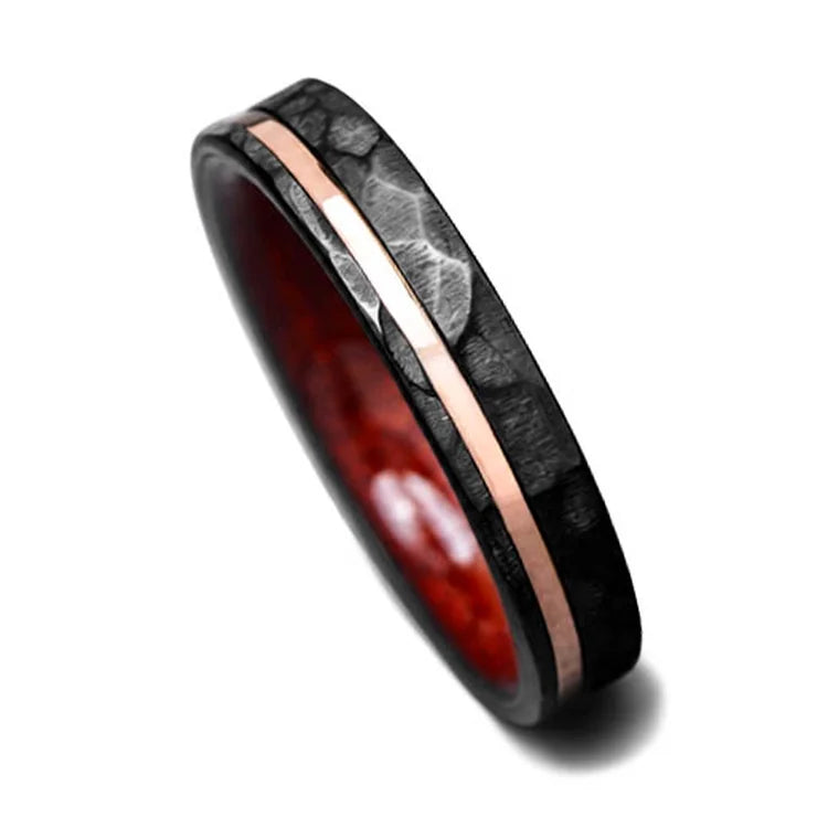 Black titanium wedding band with 14K rose gold and bloodwood inlay, featuring a custom faceted flat design, 4mm width, shown on a white background.