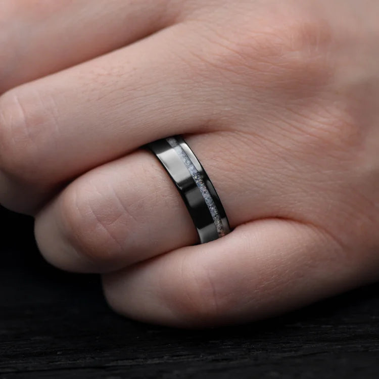 Mens wedding band featuring a black titanium ring with pearl opal inlay and bloodwood inner sleeve, polished flat profile, 6mm width, shown on a hand, free engraving available.