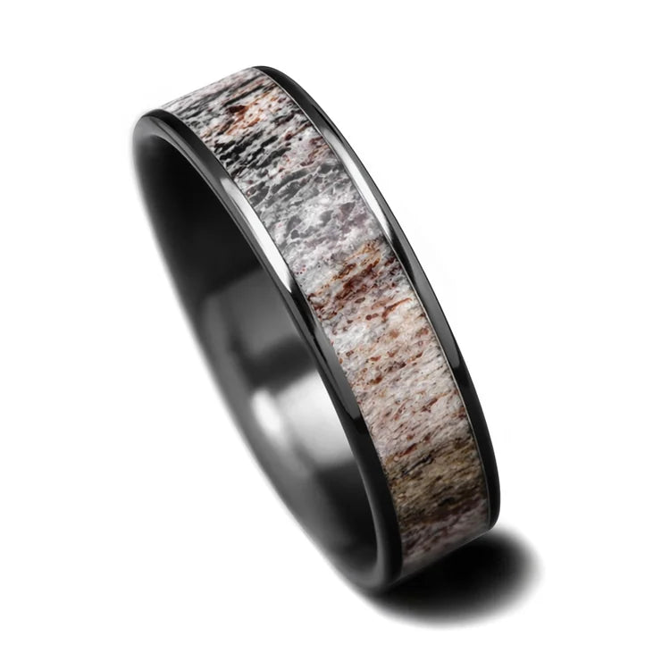 Black titanium mens wedding ring with central deer antler inlay, polished flat profile, 6mm width, unique design, free engraving available, displayed on a white background.