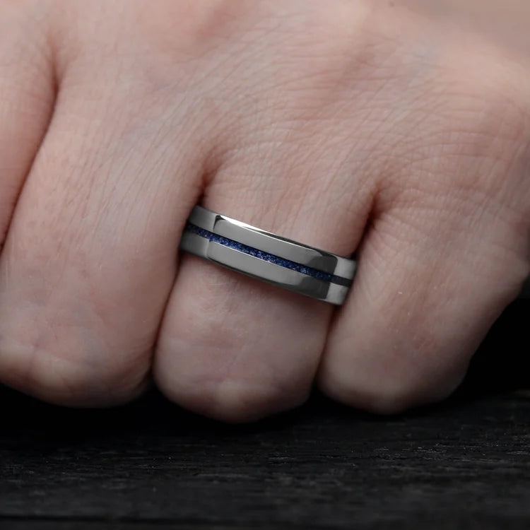 Mens titanium wedding band with central lapis lazuli inlay, 6mm polished flat profile, unique design, free engraving, worn on a hand.