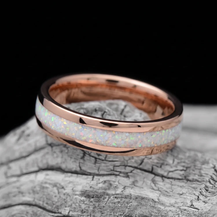 10K rose gold men’s wedding band with central pearl opal inlay and polished domed finish, resting on a white seashell
