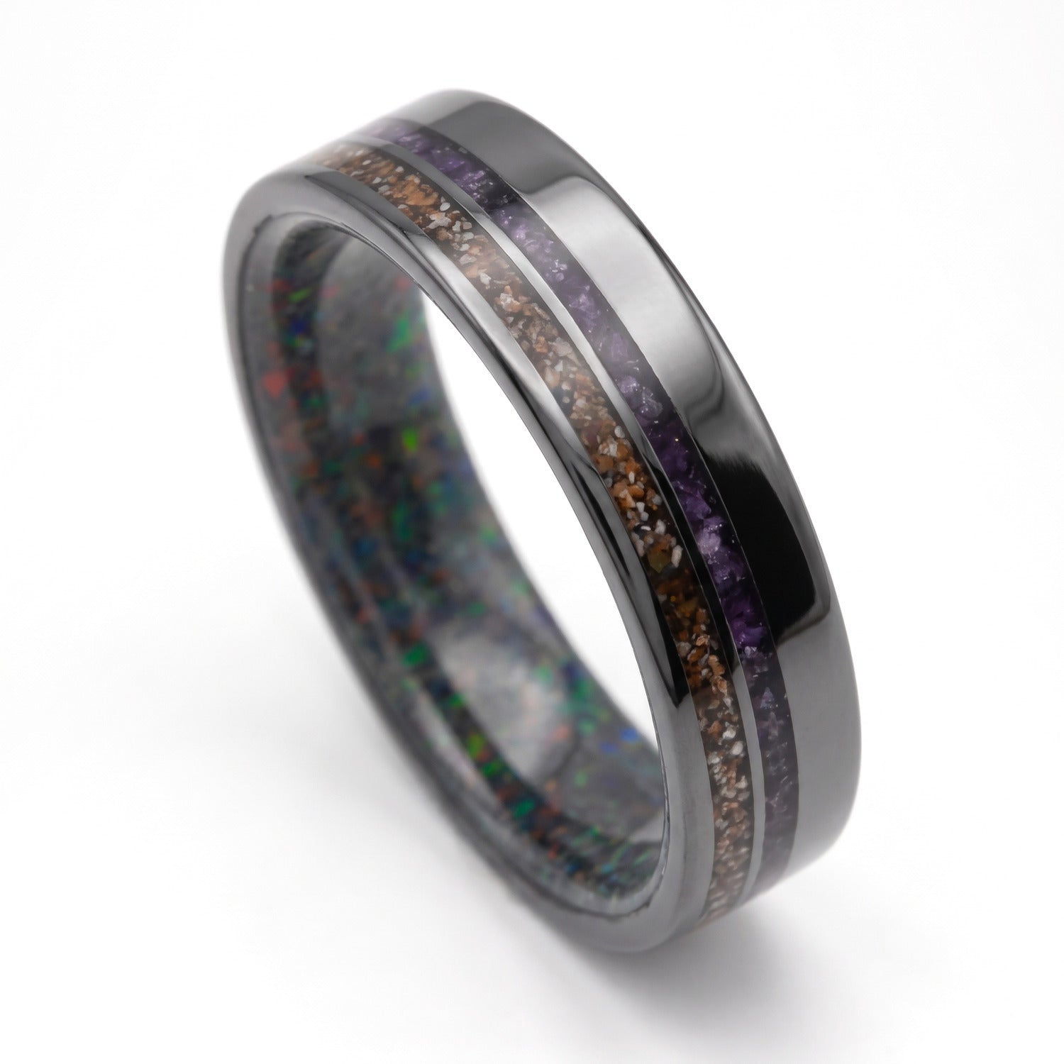 6mm black titanium mens wedding band with crushed T-Rex and amethyst inlays and a black fire opal inner sleeve on a white background