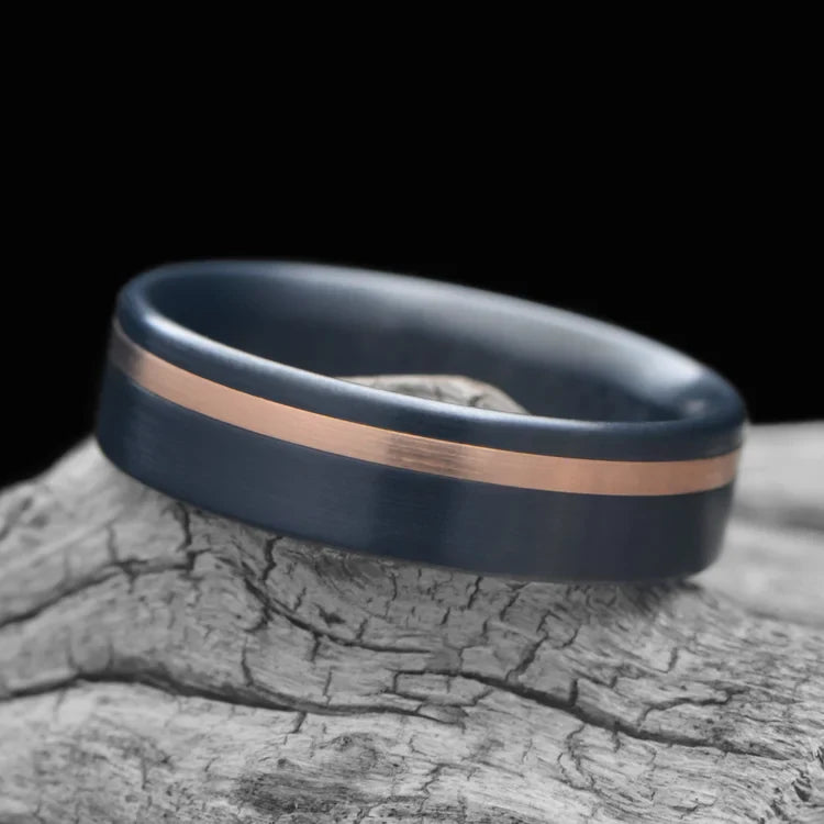 Zirconium wedding band with 14K rose gold inlay, 6mm men's ring, brushed flat profile, unique design, free engraving, displayed on white sea branch.