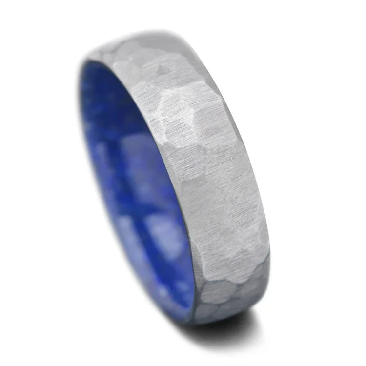 Faceted titanium ring with lapis lazuli inner sleeve, 7mm men's wedding band, unique domed design, free engraving available, displayed on a white background.