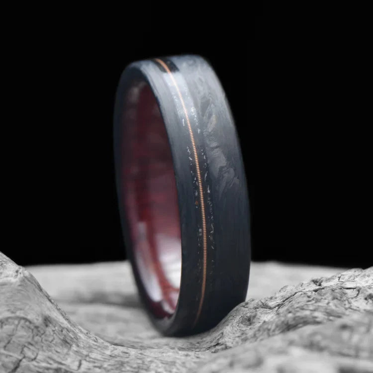 Men's 6mm matte flat profile forged wedding band with meteorite and guitar string inlay, featuring a bloodwood inner sleeve, displayed on a white sea branch, offering free engraving.