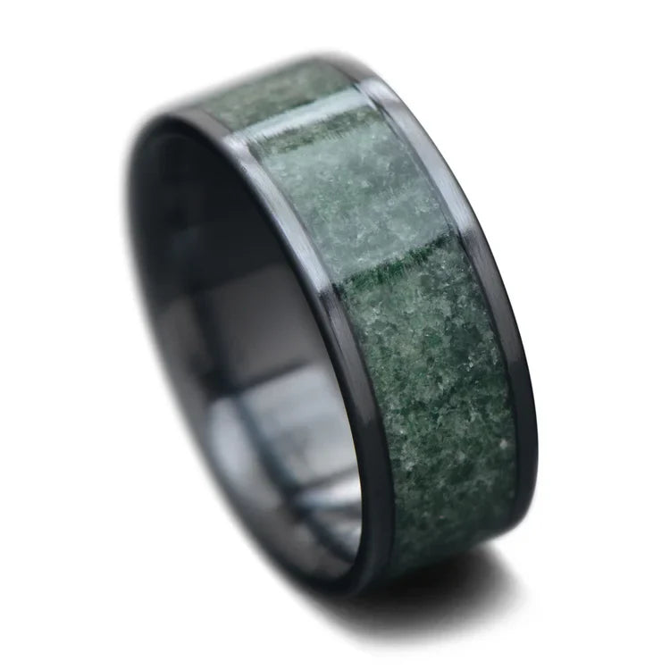 Black titanium men's wedding band featuring a central moss agate inlay, 8mm width, unique design with free engraving option, displayed on a white background.