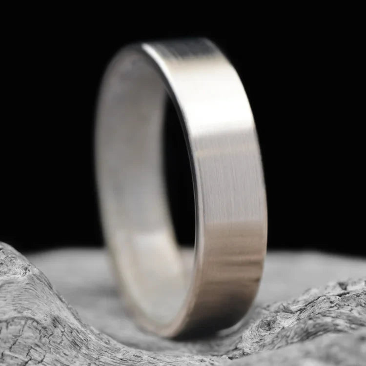 14KW mens wedding band with moonstone inner sleeve, brushed flat profile, 6mm width, custom ring with free engraving, displayed on a white sea branch background.