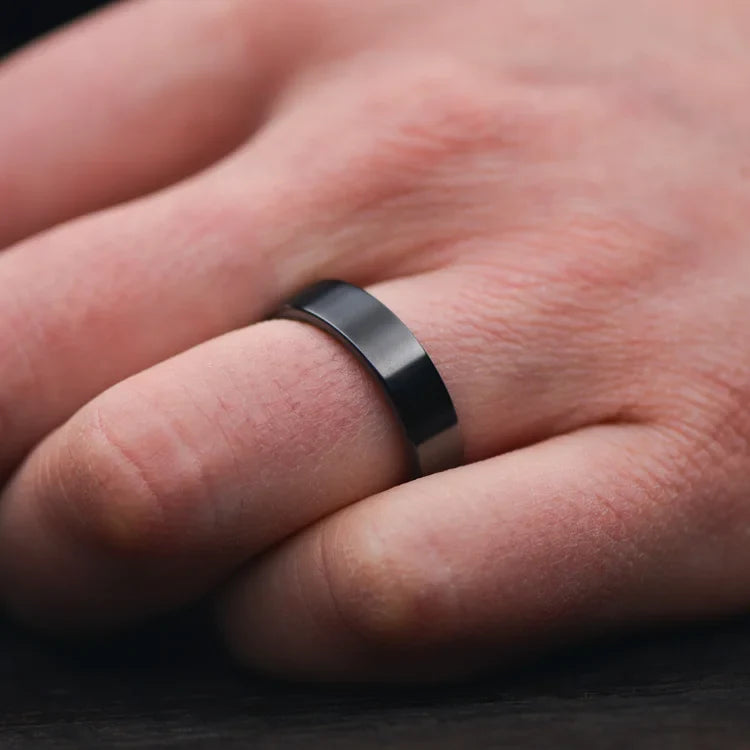 Black Titanium Wedding Band with Black Emerald Opal Inner Sleeve on a hand, showcasing its polished flat profile and 6mm width, ideal for mens wedding rings, featuring free engraving options.