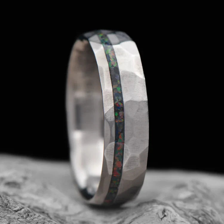 Titanium wedding band with black fire opal inlay, 6mm mens faceted domed ring, unique mens wedding band, free engraving, displayed on white sea branch.
