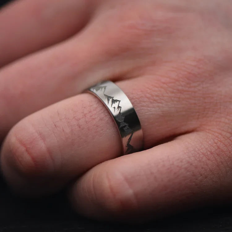 Mens titanium wedding band with brushed finish, 7mm width, shown on a hand, featuring free engraving and custom design options.