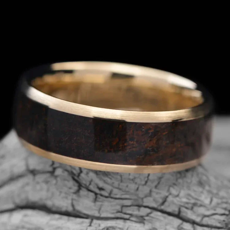 10KY gold mens wedding band with solid T-Rex central inlay, 7mm unique custom design, free engraving, displayed on white sea branch.