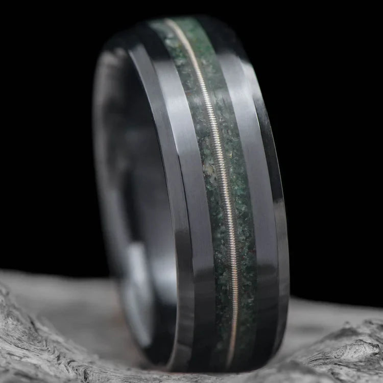 Black Titanium Wedding Band with Moss Agate and Guitar String Inlays, 7mm Mens Wedding Ring, Unique Custom Design, Free Engraving, displayed on a white sea branch.