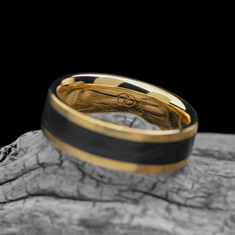 18K yellow gold mens wedding band with central forged inlay, custom brushed flat profile, 6mm width, free engraving, displayed on a white sea branch.