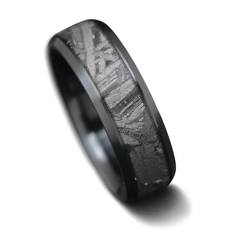 Black titanium mens wedding band with central meteorite inlay, 7mm width, unique design, free engraving available, displayed on a white background.