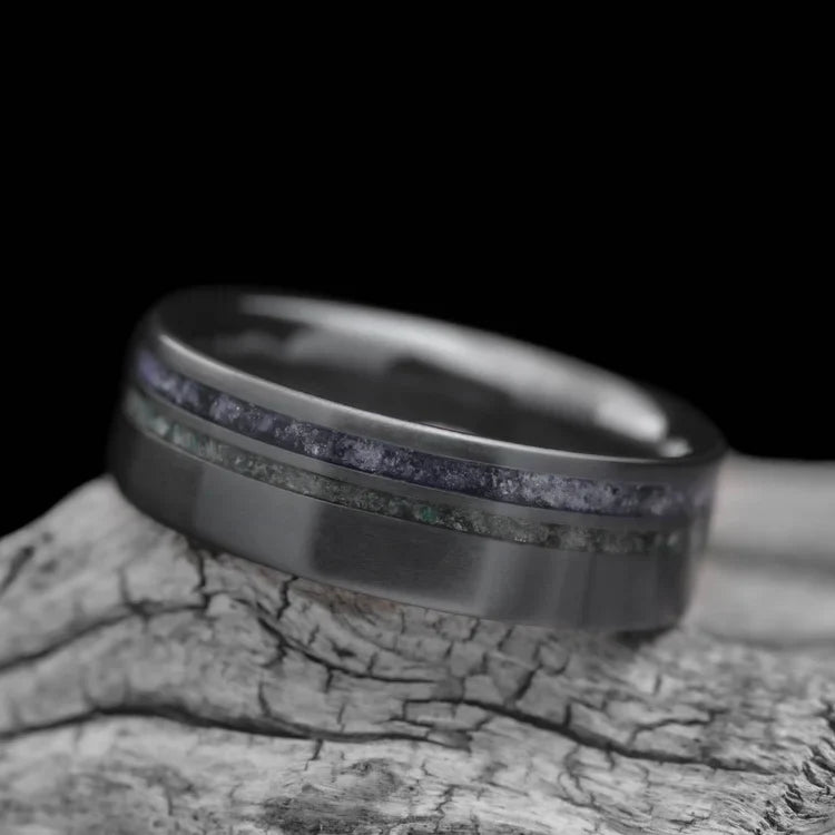Black titanium wedding band with amethyst and moss agate inlays, 7mm mens ring, unique custom design, free engraving, displayed on white sea branch.