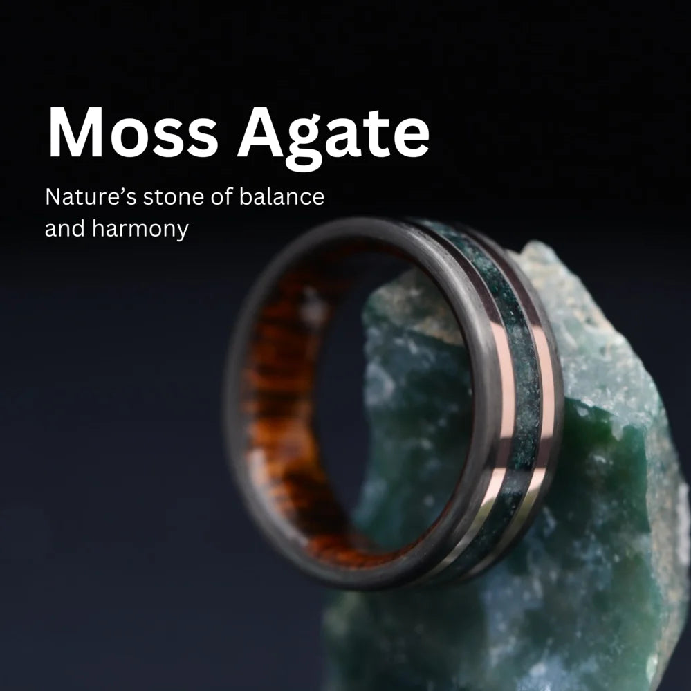 Moss Agate wedding band with rose gold inlay handcrafted by Sesto Synergy, displayed on natural moss agate stone
