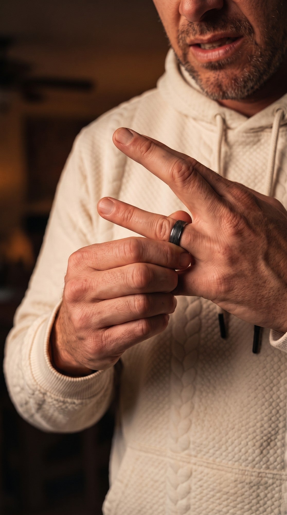 A man twisting a wedding ring stuck on his finger
