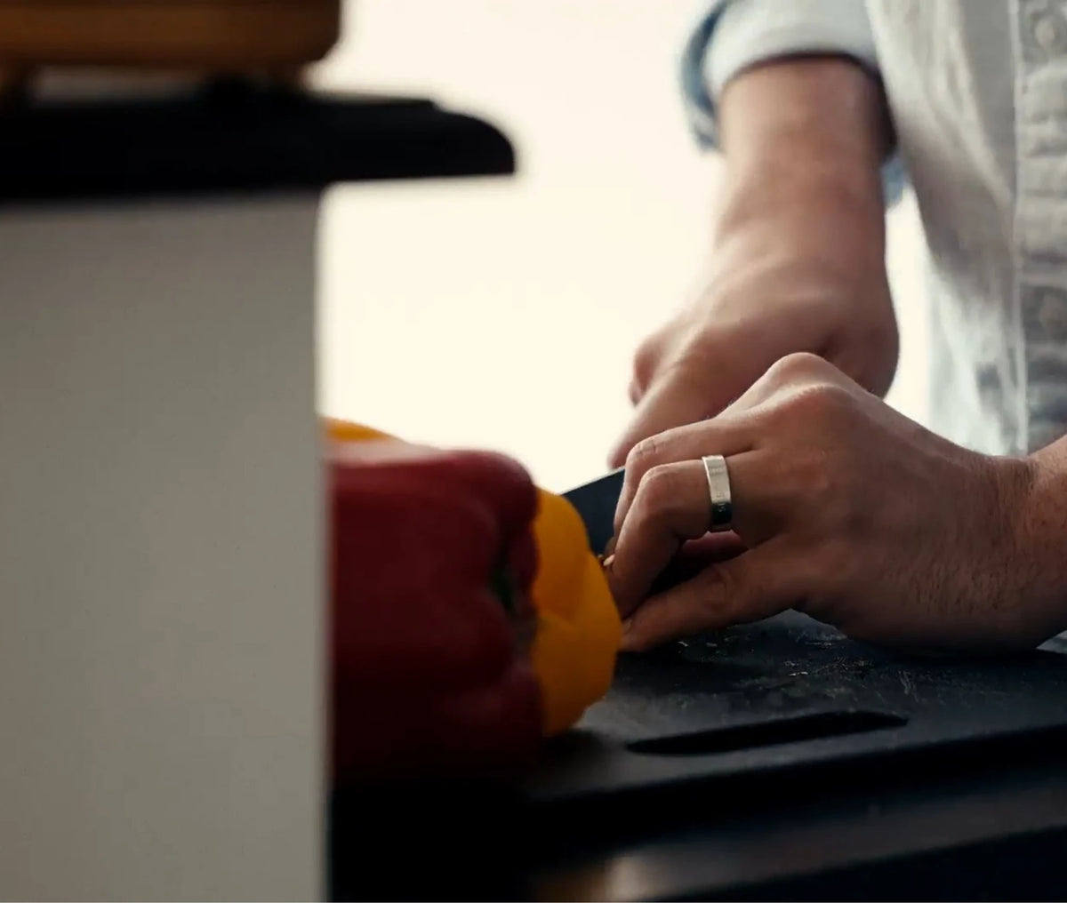 Hands chopping peppers while wearing a ring sizer